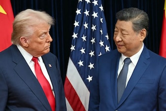 US President Donald Trump (L) and China's President Xi Jinping greet each other as they arrive for talks at the Gimhae Air Base, located next to the Gimhae International Airport in Busan on October 30, 2025.  (AFP)