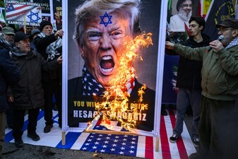 A picture of US President Donald Trump is set on fire by protesters during an anti-USA demonstration in front of the US consulate in Istanbul on February 1, 2026. (Photo by Yasin AKGUL / AFP)