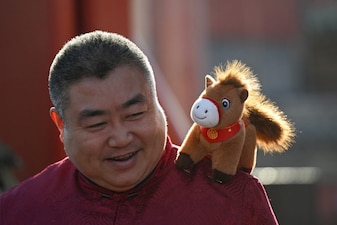 A man is seen with a horse figure on his shoulder at a temple on the first day of the Lunar New Year of the Horse in Beijing. AFP