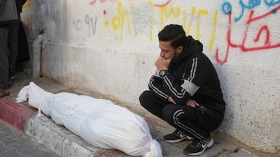 A Palestinian man mourns over Ahmed Haboush, who was killed in an Israeli military strike, at Shifa Hospital in Gaza City, Wednesday, Feb. 4, 2026. AP