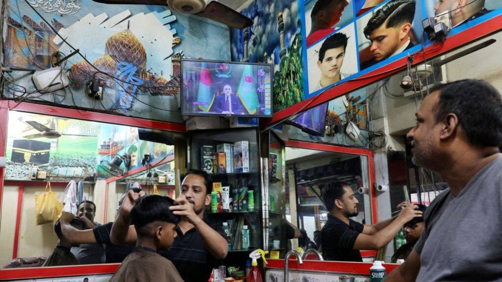 Bangladeshi Chief Election Commissioner AMM Nasir Uddin appears on a TV screen at a barbershop as he announces the schedule for the national election, in Dhaka, Bangladesh, December 11, 2025. File Image/Reuters
