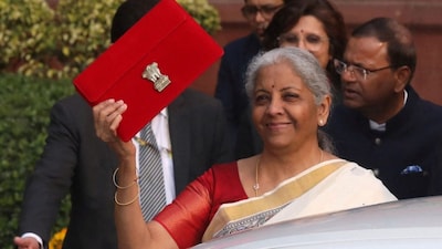 India's Finance Minister Nirmala Sitharaman holds up a folder with the Government of India's logo as she leaves her office to present the annual budget in the parliament.