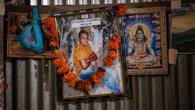 A portrait of Dipu Chandra Das, a Hindu man who was beaten to death by a mob, hangs alongside images of Hindu deities inside his home in Tarakanda village, Mymensingh District, Bangladesh, on January 9, 2026. AP File