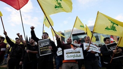 Protesters hold placards and Hezbollah flags during a demonstration condemning recent Israeli military actions in Lebanon, in Beirut, Lebanon, on February 4, 2026. Reuters File
