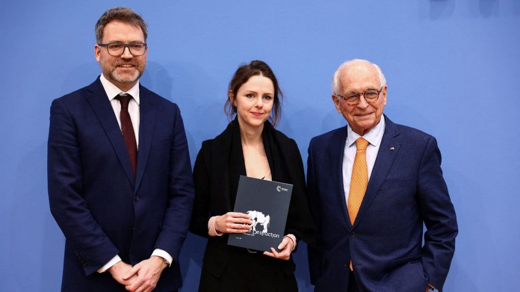 general Munich Security Conference (MSC) Head of Research and Publications Sophie Eisentraut holds a copy of the Munich Security Report 2026, while standing with MSC Foundation Council President Wolfgang Ischinger and MSC Director of Research & Policy Tobias Bunde, during a press conference in Berlin, Germany, February 9, 2026. File Image/Reuters