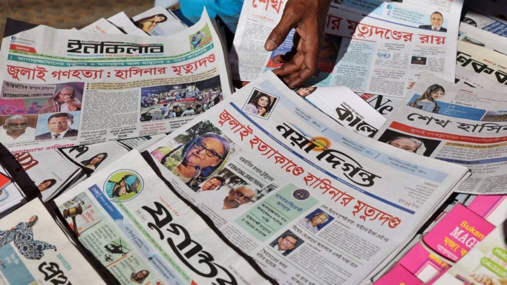 A vendor sells newspapers with headlines about the news of the ousted prime minister Sheikh Hasina's death sentence on charges of crimes against humanity for ordering a deadly crackdown on a student-led uprising last year, in Dhaka, Bangladesh, November 18, 2025. File Image/Reuters