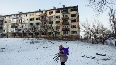 A woman, who is a school employee, walks near the site of an apartment building hit by a Russian drone strike, amid Russia's attack on Ukraine, in Kyiv, Ukraine on Wednesday. Reuters
