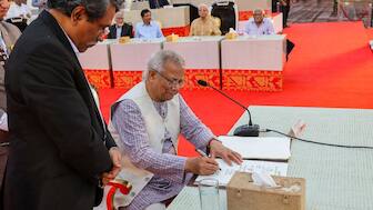 Muhammad Yunus, head of Bangladesh’s interim government, signs the July Charter during a ceremony at the National Parliament in Dhaka, Bangladesh, October 17, 2025. File Image/Bangladesh Chief Adviser’s Press Wing