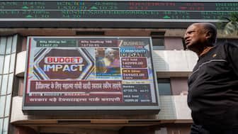 A pedestrian walks past a digital screen displaying a broadcast of the Budget speech by Finance Minister Nirmala Sitharaman at the Bombay Stock Exchange (BSE) in Mumbai. AFP