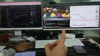 Stock traders watch Finance Minister Nirmala Sitharaman present the Budget as they trade at their terminals at an office in Mumbai. Reuters
