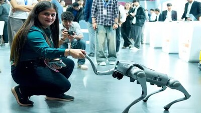 A woman looks at the robot dog displayed by Galgotias University at the India AI Impact Summit, which later turned out to be a Chinese-made innovation. Image Courtesy: Galgotias/Facebook