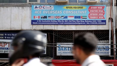 Motorists move past an advertisement of a visa consultancy office in New Delhi. A new bill has been introduced in the US Congress seeking to end the H-1B visa programme. File photo/Reuters