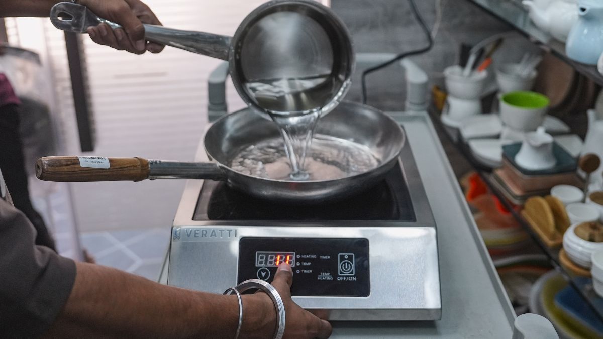 A cook prepares food on an induction cooktop amid LPG shortages affecting restaurants, in Mumbai, March 11, 2026. PTI A cook prepares food on an induction cooktop amid LPG shortages affecting restaurants, in Mumbai, March 11, 2026. PTI