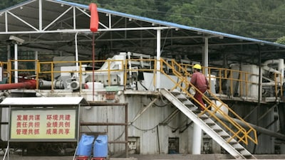 A worker makes his way onto an operation space at an exploration site in the Longgang gas field in Lishan, in southwest China's Sichuan province. (File/AFP)
