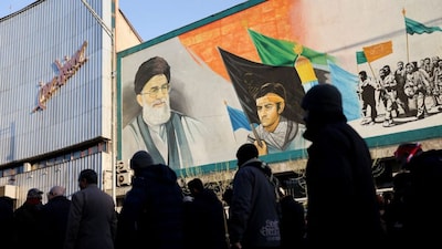 People walk near a mural featuring an image of Iran's Supreme Leader Ayatollah Ali Khamenei as people gather after Khamenei was killed in Israeli and US strikes on Saturday, in Tehran, Iran, on March 1, 2026. (Photo: Majid Asgaripour/WANA via Reuters)