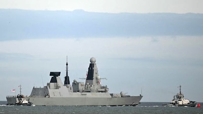HMS Dragon, a Royal Navy Type 45 Daring-class air-defence destroyer warship, is guided by tug boats as it departs from HM Naval Base Portsmouth on March 10, 2026. (Photo: Justin Tallis/AFP)