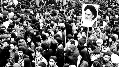 Supporters of the leader and founder of the Islamic revolution Ayatollah Khomeini hold his picture in Tehran during the country's revolution in February 1979. File Image/Reuters