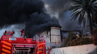 Smoke billows from the site of a strike on the outskirts of Tel Aviv as firefighters work to extinguish the fire on March 13, 2026.- AFP