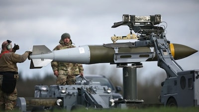 US Military personnel take away Joint Direct Attack Munitions (JDAMs), removed from a US Air Force B-1 Lancer bomber at RAF Fairford in south-west England on March 15, 2026.- AFP
