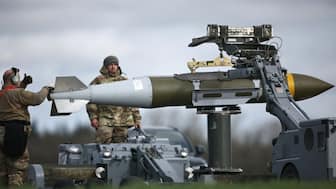 US Military personnel take away Joint Direct Attack Munitions (JDAMs), removed from a US Air Force B-1 Lancer bomber at RAF Fairford in south-west England on March 15, 2026.- AFP