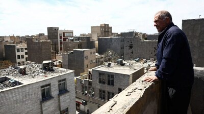 A man looks at a residential building damaged by a strike, amid the US-Israeli conflict with Iran, in Tehran, Iran, March 27, 2026. File Image/WANA via Reuters
