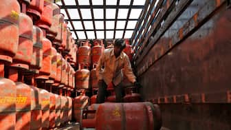 A worker unloads liquefied petroleum gas (LPG) cooking cylinders from a supply truck outside a distribution centre in the western Indian city of Ahmedabad. File image/Reuters