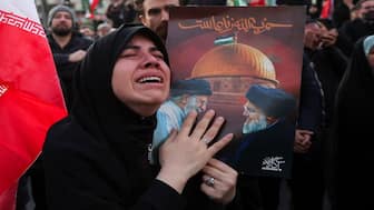 A woman reacts as people gather at the Enghelab Square, after Iran's Supreme Leader Ayatollah Ali Khamenei was killed in Israeli and US strikes on Saturday, in Tehran, Iran. Reuters