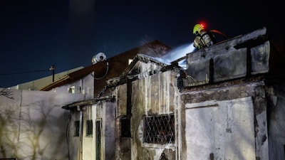 A firefighter works at the site of a strike in the northern Israeli city of Nahariya on March 16, 2026. (AFP)