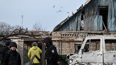Ukrainian servicemen hit a Russian drone as police officers work at the site of a building hit by a Russian drone strike, amid Russia's attack on Ukraine, in Zaporizhzhia, Ukraine March 21, 2026. REUTERS/Stringer