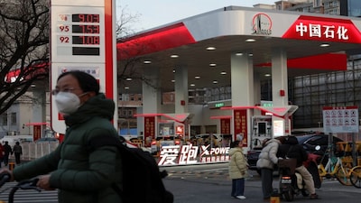 A cyclist waits to cross a road near a Sinopec gas station in Beijing, China. File/Reuters