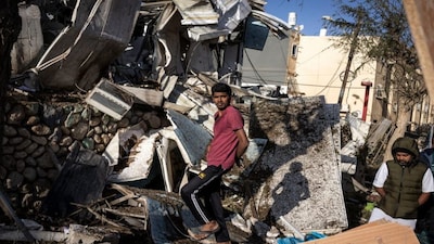 People inspect the site of an Iranian missile strike in Dimona. Iranian missile strikes on two southern Israeli towns wounded more than 100 people, medics said, after Israeli air defence systems failed to intercept the projectiles. AFP
