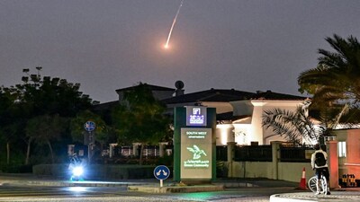 A cyclist watches as a projectile falls over Dubai on February 28. AFP correspondents heard a loud explosion in Dubai  and one of them saw a plume of smoke rising from the city in the wake of wide-ranging Iranian attacks on the Gulf. AFP