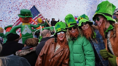 Women wearing leprechaun hats and beards smile as confetti cannons blast during the annual St. Patrick's Day parade in South Boston. AP Photo
