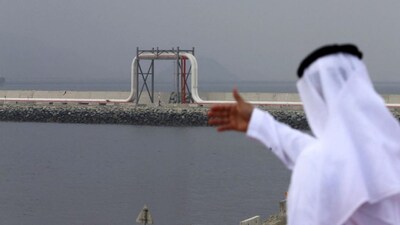 An Emirati man stands in front of a pipeline at the oil terminal of Fujairah. File image/AFP