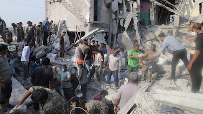 People and rescue forces work following a reported strike on a school in Minab, Iran, on February 28. More than 160 people were killed in the air strike on the first day of the conflict. Reuters