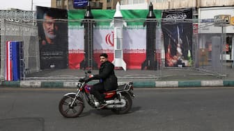 A motorist rides past the dummy models of Iranian missiles installed along the roadside at the Valiasr Square, in Tehran. The war is nearing the one-month mark, with no signs of it abating. AFP
