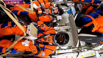 Nasa astronaut Christina Koch adjusts her helmet visor next to CSA (Canadian Space Agency) astronaut Jeremy Hansen in the Orion crew capsule before the planned Artemis II launch mission to fly by the moon, at the Kennedy Space Centre in Cape Canaveral, Florida, US, April 1, 2026, in a still image from video. Nasa TV/Handout via Reuters