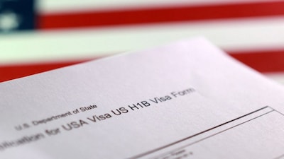 A US flag and a US H-1B Visa application form. Reuters File