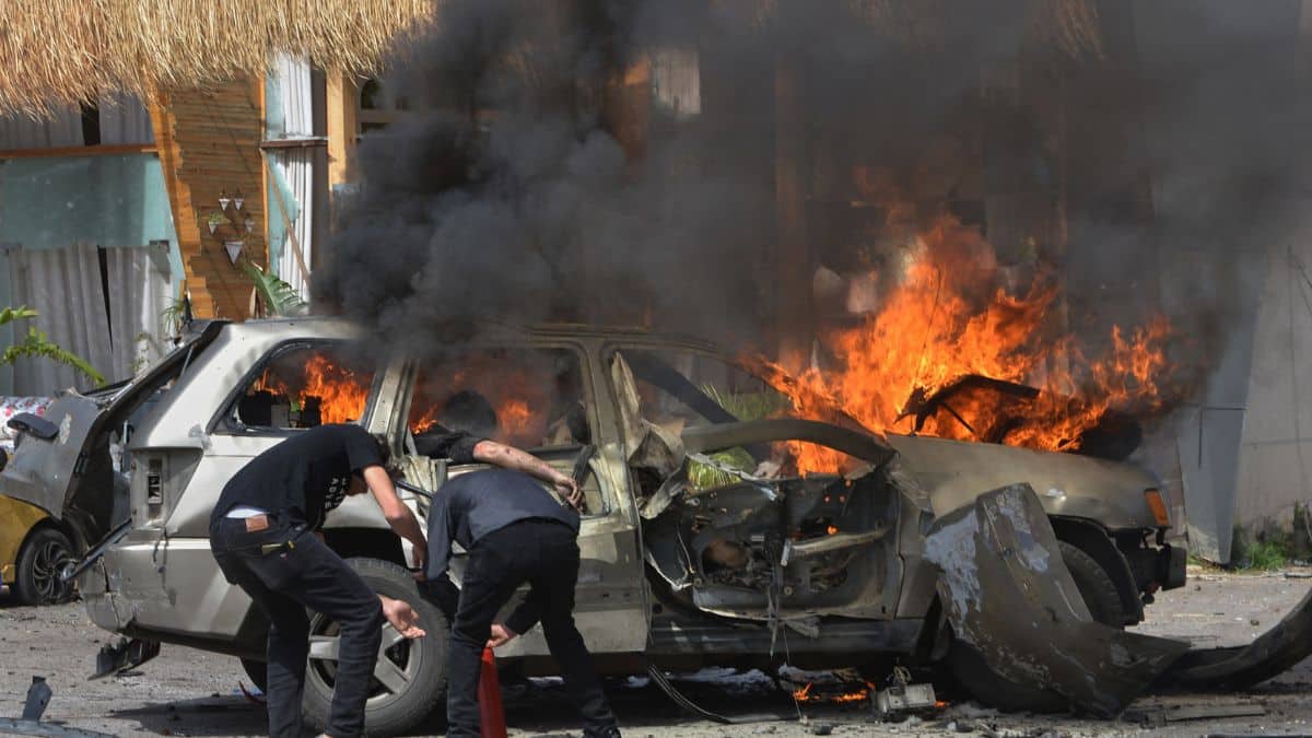A person is seen inside a burning vehicle as men attempt to put out the fire after an Israeli airstrike hit a car in the coastal town of Barja, south of Beirut, Lebanon, Wednesday, May 13, 2026. (AP Photo)