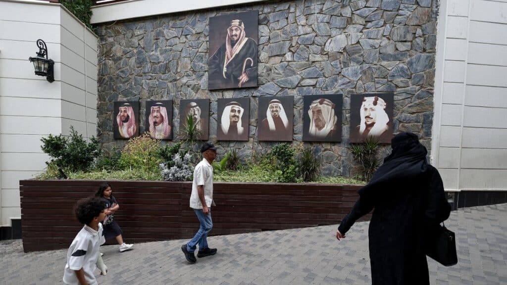 Visitors pass by images of Saudi King Salman bin Abdulaziz Al Saud, Crown Prince Mohammed bin Salman and previous kings of Saudi Arabia, as they arrive at a tourist spot in Abha, Saudi Arabia, August 19, 2025. File Image/Reuters