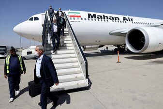 Passengers get off from a privately owned Iranian airline Mahan Air flight at the airport in Kabul on September 15, 2021. (Photo by Karim SAHIB / AFP)
