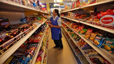 A worker arranges food packets inside a retail store in Kolkata. File/Reuters