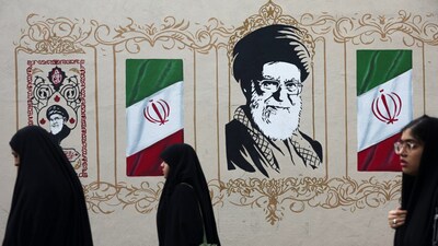 People walk by a mural depicting Iran's late Supreme Leader Ayatollah Ali Khamenei, on a street in Tehran, Iran. File/Reuters