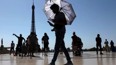 A tourist holding an umbrella at Trocadero Square next to the Eiffel Tower in Paris, France. File/Reuters