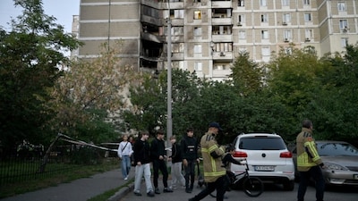 Children gather outside a multi-storey residential building after a fire following an aerial strike in Kyiv on September 27, 2026, amid the Russian invasion of Ukraine. AFP