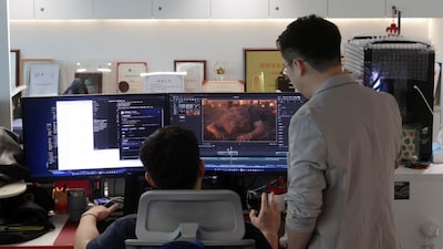 Zhu Zhili, a Chinese AI director, discusses an AI-generated video with a colleague at the office of China Wit Media, a film and television production company, in Shenzhen, Guangdong province, China August 17, 2026. REUTERS/Ellen Zhang
