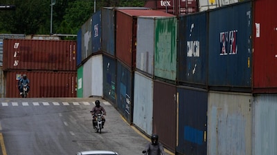 Motorcyclists drive past shipping containers placed by authorities to seal off an area ahead of a plan protest march by the supporters of imprisoned former Prime Minister Imran Khan demanding his release in Islamabad, Pakistan, on September 28, 2026. (Photo: Anjum Naveed/AP)