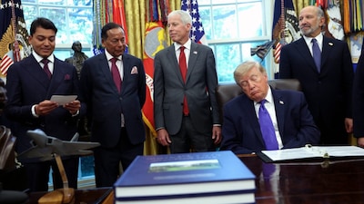 US President Donald is caught with his eyes shut during a Monday Oval Office event announcing a new $15 billion steel plant in Iowa. AFP