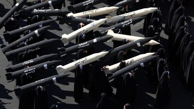 Female members of Iranian militia forces carry missile mock-ups during a military march in Tehran, Iran. War clouds are gathering yet again after Iran claimed it had received intelligence that the US was preparing for a renewed bombing campaign against the Islamic Republic. Reuters