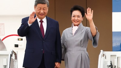 Chinese President Xi Jinping and his wife, Peng Liyuan, wave as they arrive at Joint Base Andrews, Maryland, US. Liyuan looks fashionable as ever in her grey outfit. Reuters